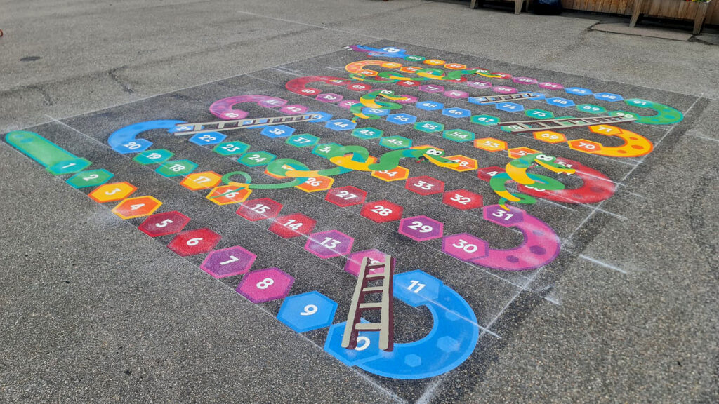 Snakes and ladders playground marking freshly installed on a school tarmac surface