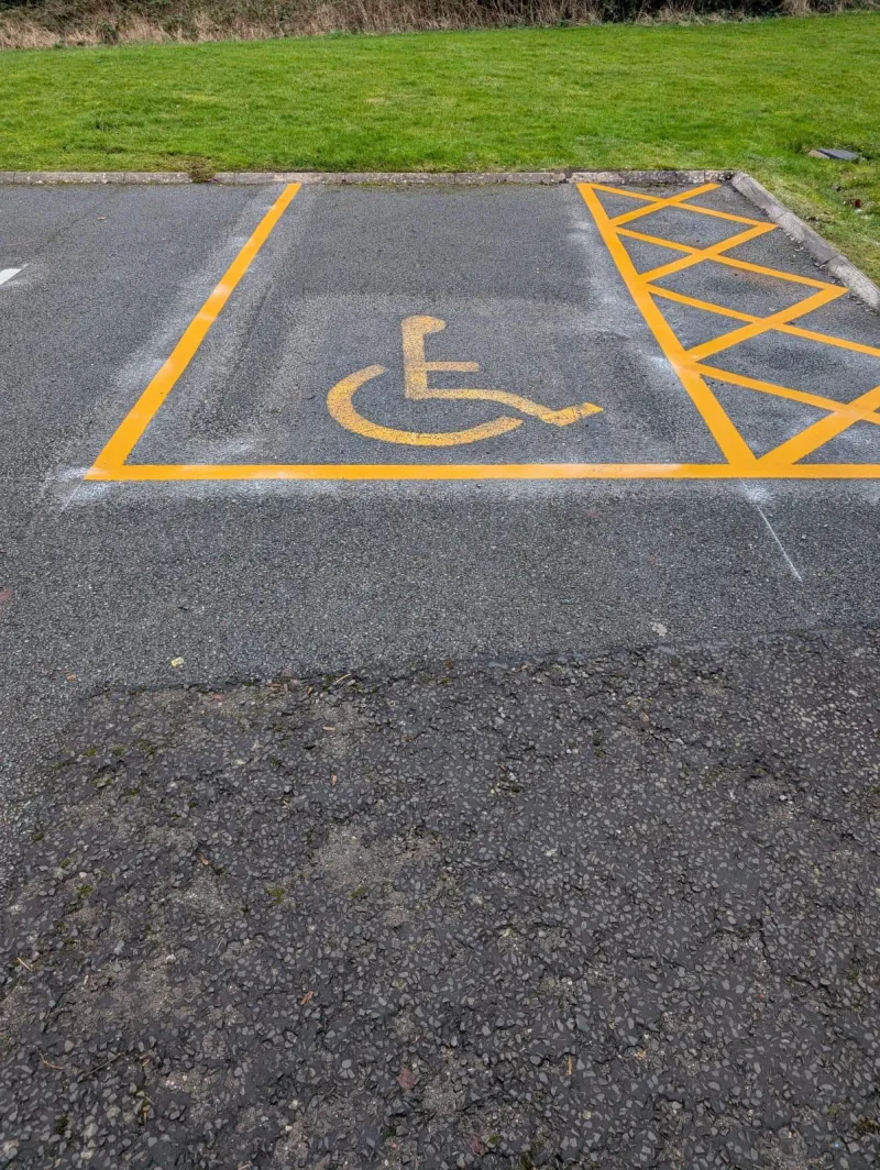 Accessible disabled parking bay with a wheelchair symbol and yellow access hatching