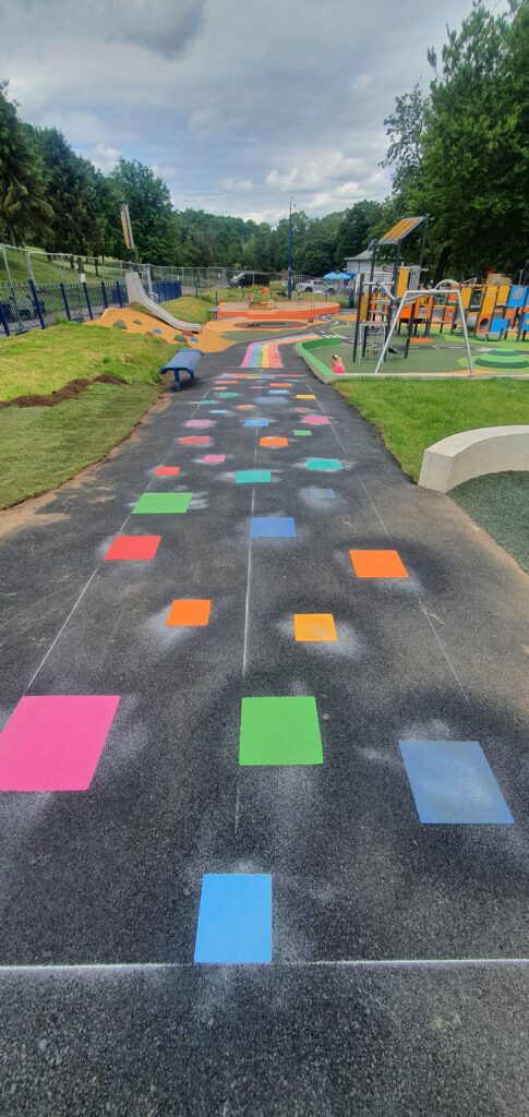 Colourful footprint and route trail markings guiding a path across a school surface