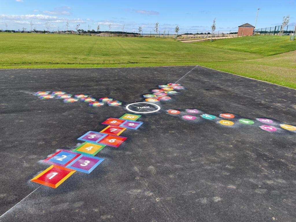 Colourful hopscotch markings numbered one to ten on playground tarmac