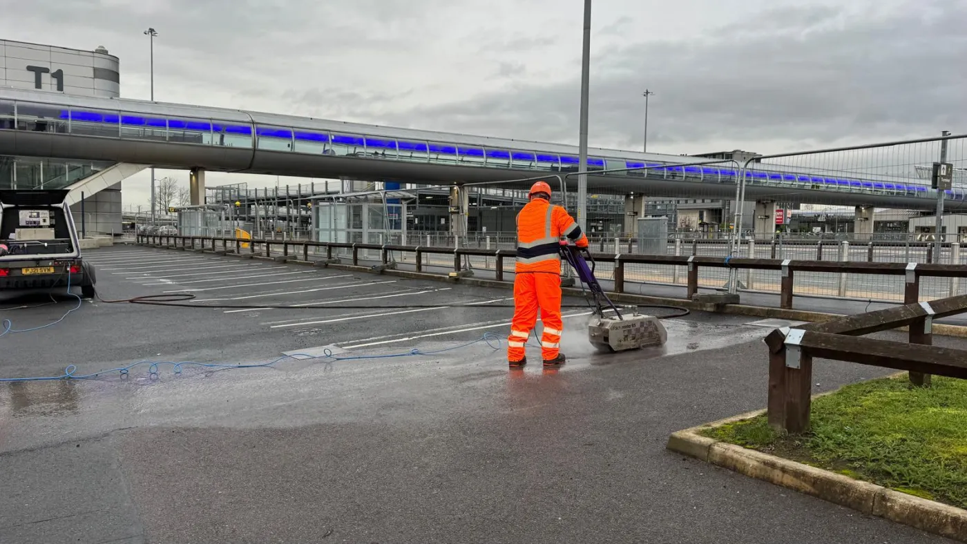 A Uniplay operative assessing and removing existing markings from a hard surface before agreeing the method